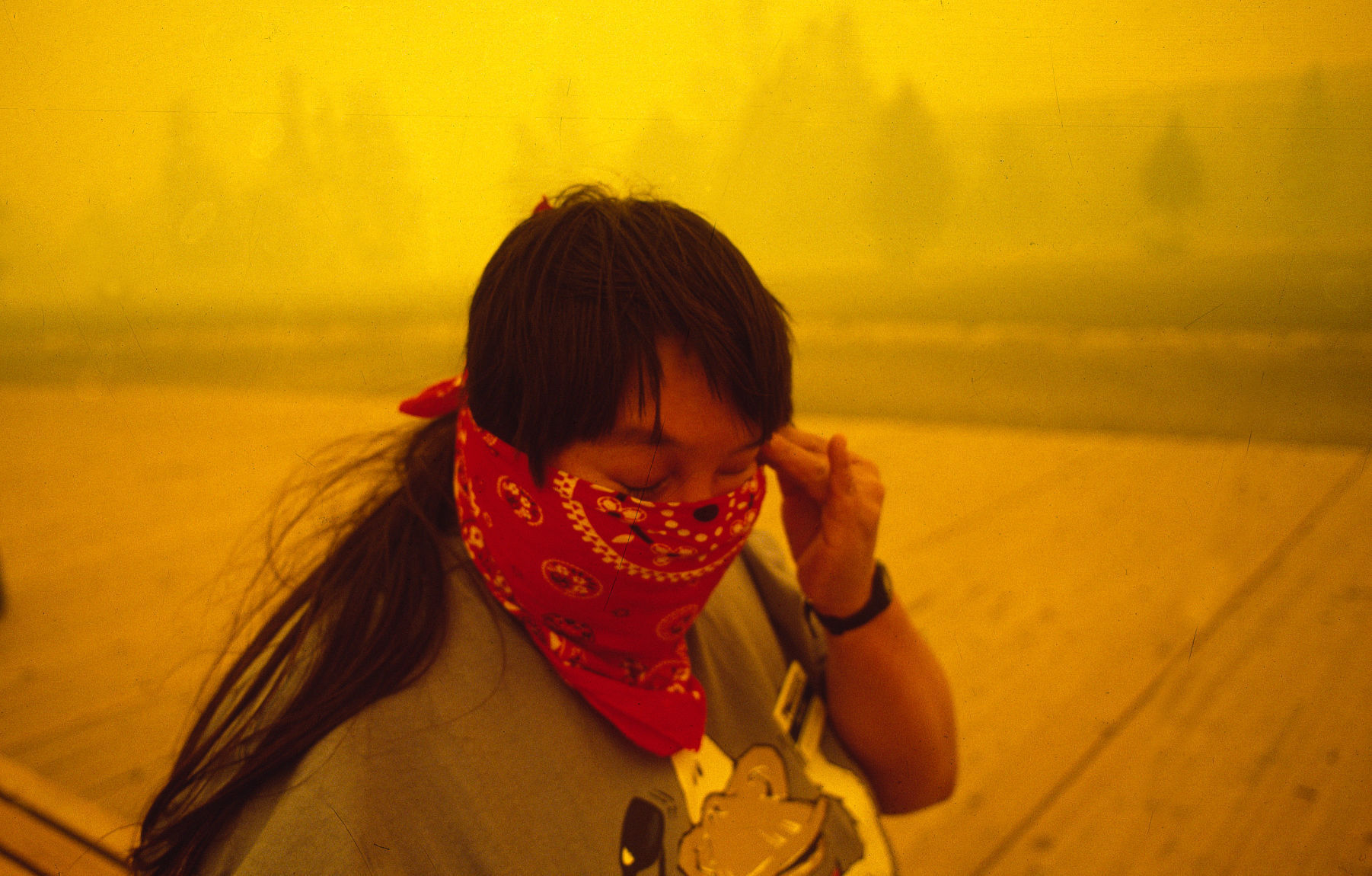 Sue Horn wipes her eyes as smoke fills the air at Old Faithful